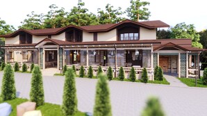 A modern two-story house with a covered porch, multiple windows, and a well-maintained garden.