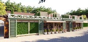 A row of green-tiled buildings with white railings, potted plants, and a bicycle. - Complex Turistic Codru (Burcuta)