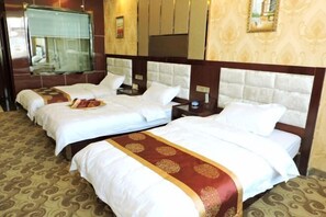 Ein Hotelzimmer mit zwei Betten, jeweils mit weißer Bettwäsche und einem roten Dekorationsläufer.