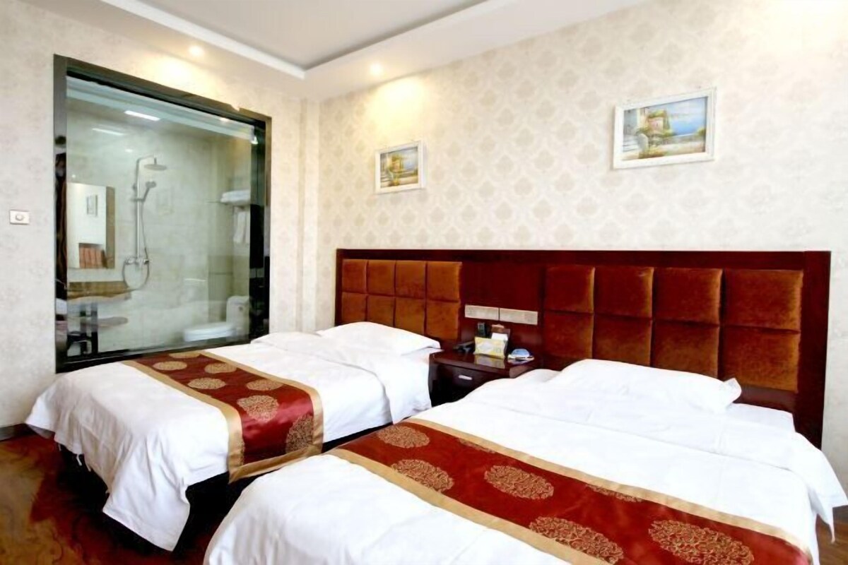 Ein Hotelzimmer mit zwei Betten, einem großen Spiegel und einer Duschkabine.