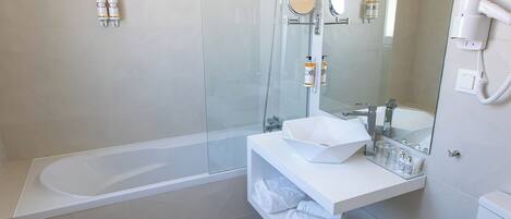 A modern bathroom with a glass-enclosed shower, a white sink, and a large mirror.