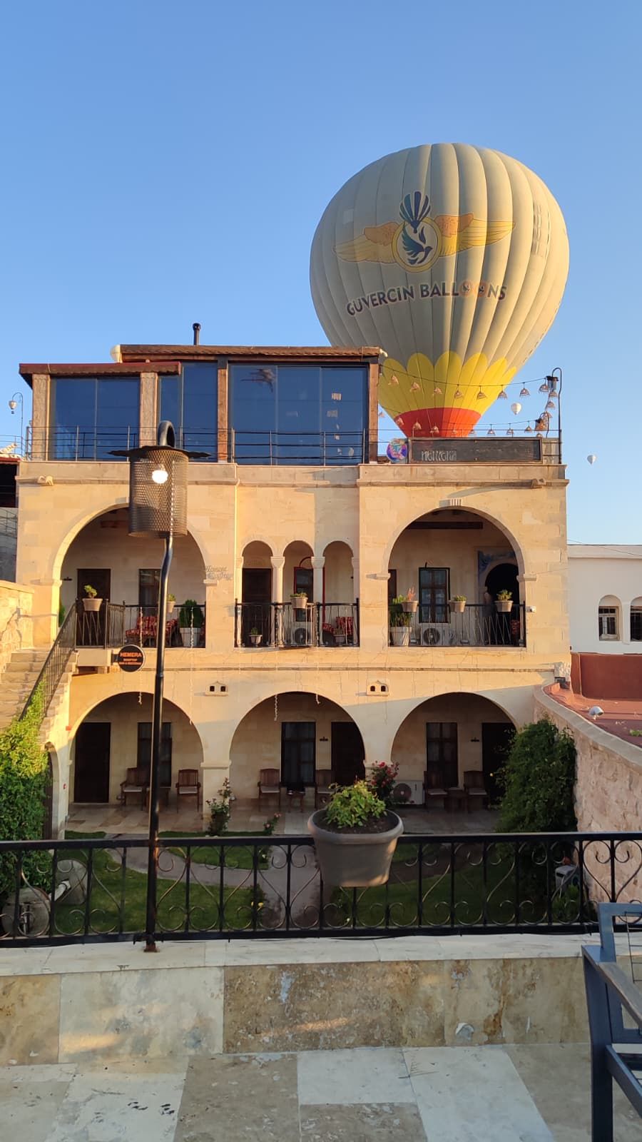 A building with multiple balconies, a hot air balloon, and a sign indicating a restaurant.