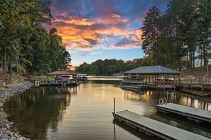 A calm lake with docks, a gazebo, and a covered pavilion. - Turtle Cove by SoCharm | Waterfront Home with Hot Tub (Mooresville)
