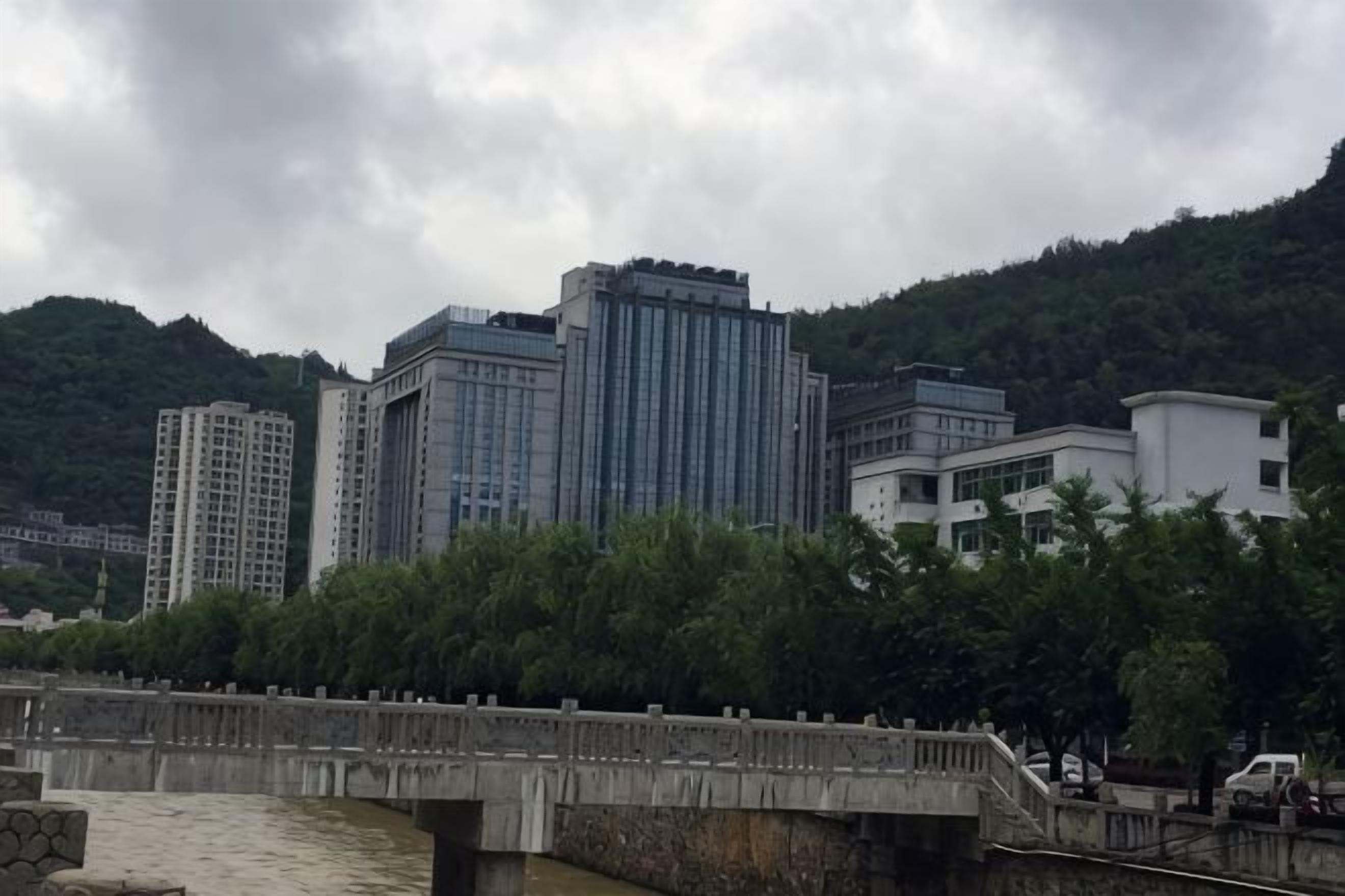 A bridge over a river with buildings in the background.