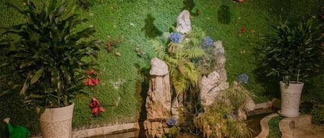 Una pared con vegetación y algunas rocas.