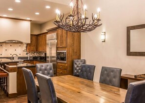Enjoy meals in the spacious kitchen and dining area, featuring a central island, dining table, and six comfortable chairs.