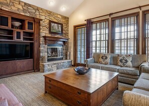Cozy living room with a fireplace, flat-screen TV, and comfortable seating area.