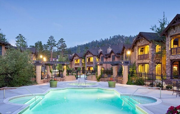 Relax by the pool surrounded by lush greenery and comfortable lounge chairs.