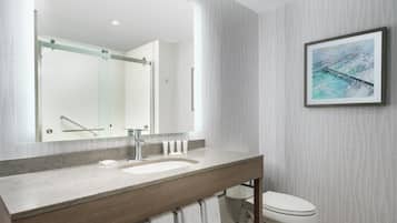 Een moderne badkamer met een grote spiegel, een wastafel en een toilet.