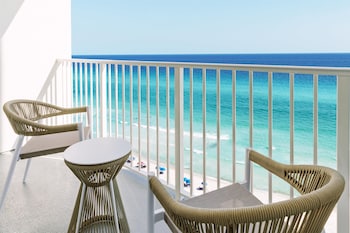A modern indoor pool area with multiple seating areas and a central pool. at Hyatt Place Panama City Beach