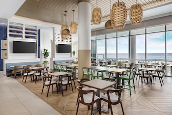 A modern reception area with a wooden desk, multiple computer monitors, and a decorative wall. at Hyatt Place Panama City Beach