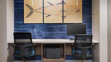 A modern office desk with two chairs, a computer, and a printer.