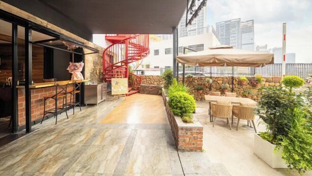 Une terrasse extérieure dotée d’un escalier en colimaçon, d’un coin bar et de plusieurs places assises.