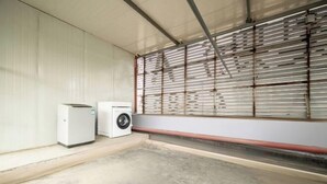 Une pièce dotée d’une grande fenêtre, d’un lave-linge et d’un sèche-linge.