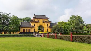 A traditional building with a large archway, surrounded by a well-maintained lawn and trees. - City Comfort Inn (Guilin)
