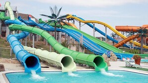 Um parque aquático com vários escorregadores e piscina.