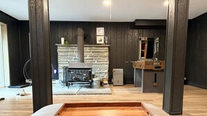 Ein modernes Wohnzimmer mit Kamin aus Stein, einem Couchtisch aus Holz und einer TV-Konsole.