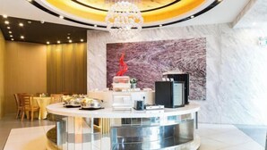 A modern hotel lobby with a central round bar area, a chandelier, and a marble wall. - Jinjiang Inn (Yancheng Dongtai high-speed railway station Fangong North Road Branch) (Dongtai)