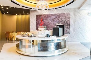 A modern hotel lobby with a central round bar area, a chandelier, and a marble wall. - Jinjiang Inn (Yancheng Dongtai high-speed railway station Fangong North Road Branch) (Dongtai)