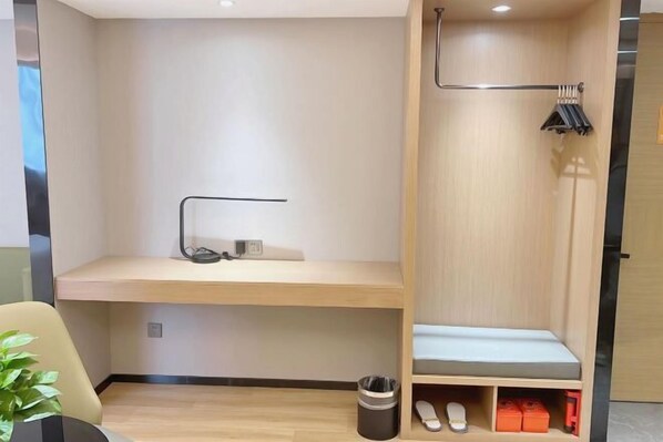 Una camera moderna e funzionale con una scrivania in legno, una panca e un port scarpe.