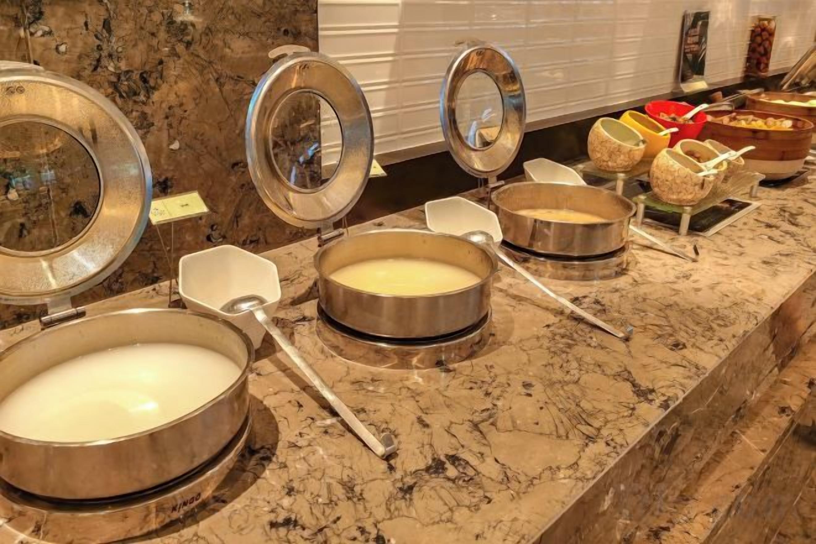 Montaje de bufé con varias estaciones de servicio, incluyendo fuentes de comida y utensilios.