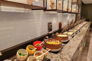 A buffet setup with various food items and utensils. - Nanan Hotel (Nan'an)