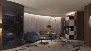 Un salon moderne avec un mur incurvé, un canapé, une table basse, une lampe et un meuble.