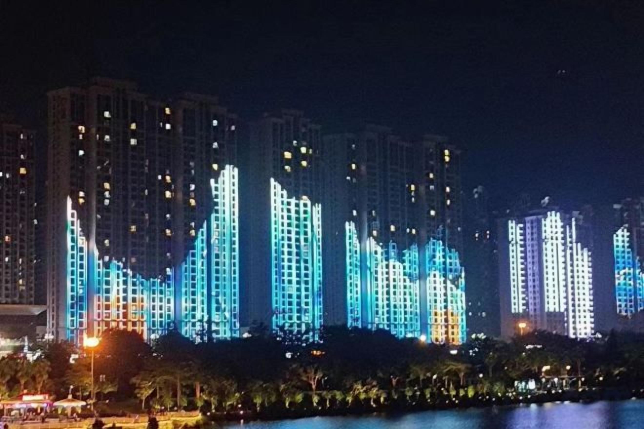 A nighttime view of high-rise buildings with illuminated facades.