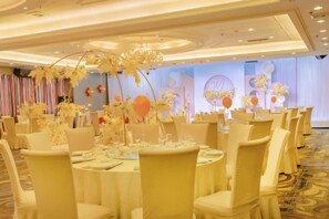 A banquet hall with round tables, chairs, and floral centerpieces. - Nanan Hotel (Nan'an)