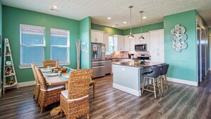 A modern kitchen with white cabinets, stainless steel appliances, and a central island.
