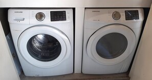 Deux lave-linge Samsung à chargement frontal, de couleur blanche, placés côte à côte.