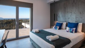 Een moderne slaapkamer met een groot bed, uitzicht door een schuifdeur en een wand van beton.