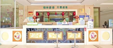 A reception desk with a counter, two stools, and decorative elements.