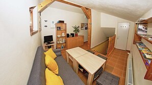 A compact living space with a sofa, table, and wooden beams. - VILA RHEA - Ubytovanie Vysoke Tatry (Vazec)