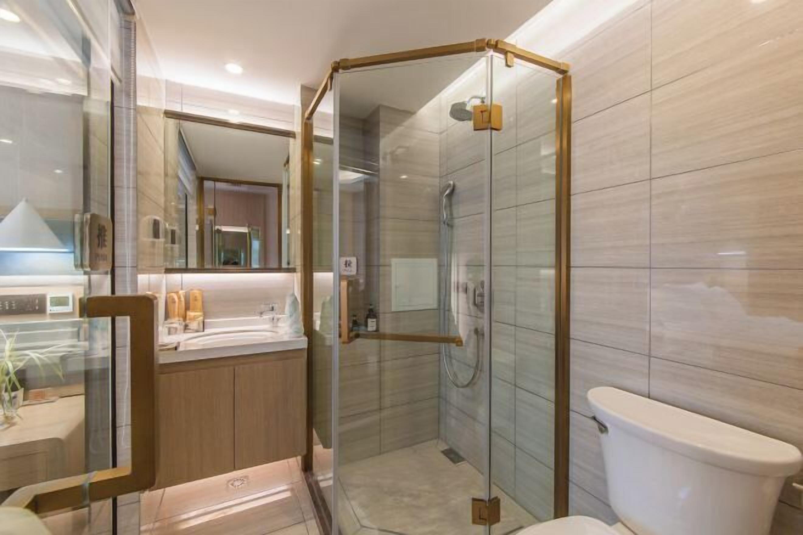 Ein modernes Badezimmer mit einer Duschkabine, einer Toilette und einem Waschtisch mit Spiegel.