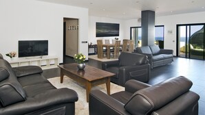 A modern living room with leather sofas, a wooden coffee table, and a flat-screen TV. - Casa Aurora with sea view and beautiful terrace, Iberlagos Resort (Lagos)