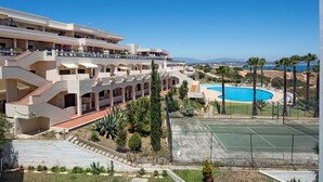 A hotel with multiple balconies, a swimming pool, tennis courts, and a view of the sea. - Casa Aurora with sea view and beautiful terrace, Iberlagos Resort (Lagos)