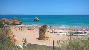 A beach with rocky formations, umbrellas, and beach chairs. - Casa Aurora with sea view and beautiful terrace, Iberlagos Resort (Lagos)