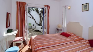 A bedroom with a bed, a chair, a desk, and a window with curtains. - Casa Alma Mar, 2 minutes' walk to the beach (Luz)