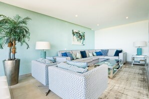 A modern living room with a sofa set, a coffee table, a potted plant, and a painting on the wall. - Casa Sara, Iberlagos Resort, breathtaking sea view (Lagos)