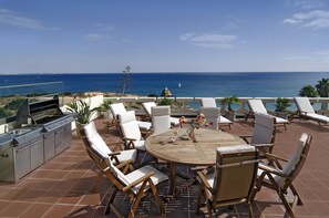 A patio with outdoor furniture, a grill, and a view of the ocean. - Casa Sara, Iberlagos Resort, breathtaking sea view (Lagos)
