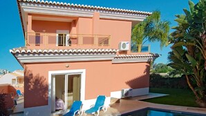 A two-story building with a swimming pool, a balcony, and a door leading to an interior space. - Quinta Marina with sea views, private pool and garden (Lagos)