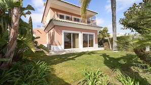 A two-story house with a balcony, surrounded by tropical plants and a well-maintained lawn. - Quinta Marina with sea views, private pool and garden (Lagos)