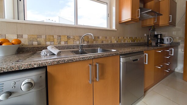 A modern kitchen with granite countertops, stainless steel appliances, and wooden cabinets. - Quinta Marina with sea views, private pool and garden (Lagos)