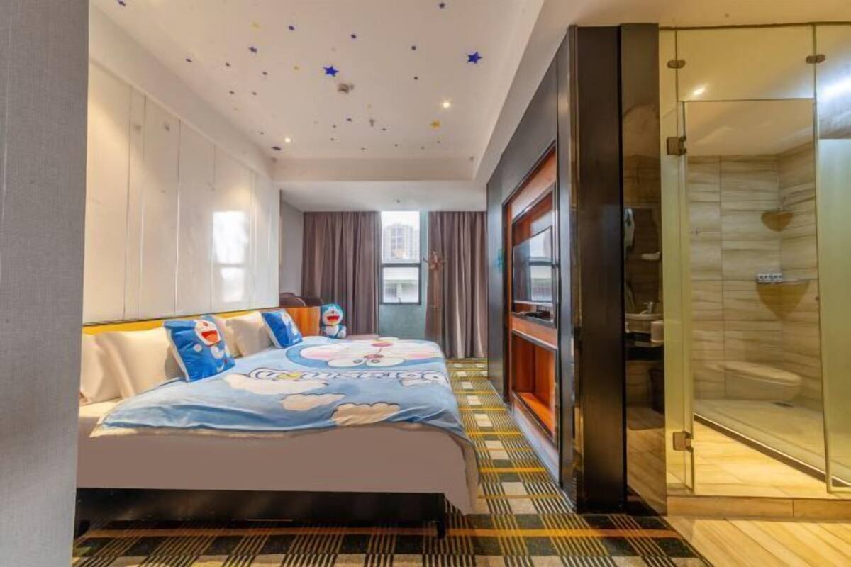 Une chambre d’hôtel avec un lit, une douche en cabine de verre et une vue sur la ville.