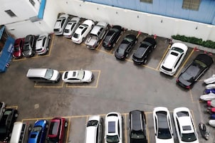 Un estacionamiento con varios coches aparcados en filas.