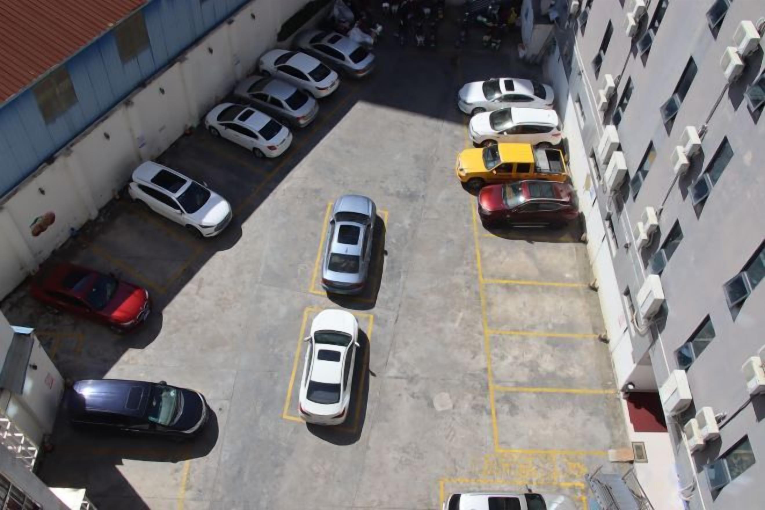 An aerial view of a parking lot with multiple cars parked in designated spaces.