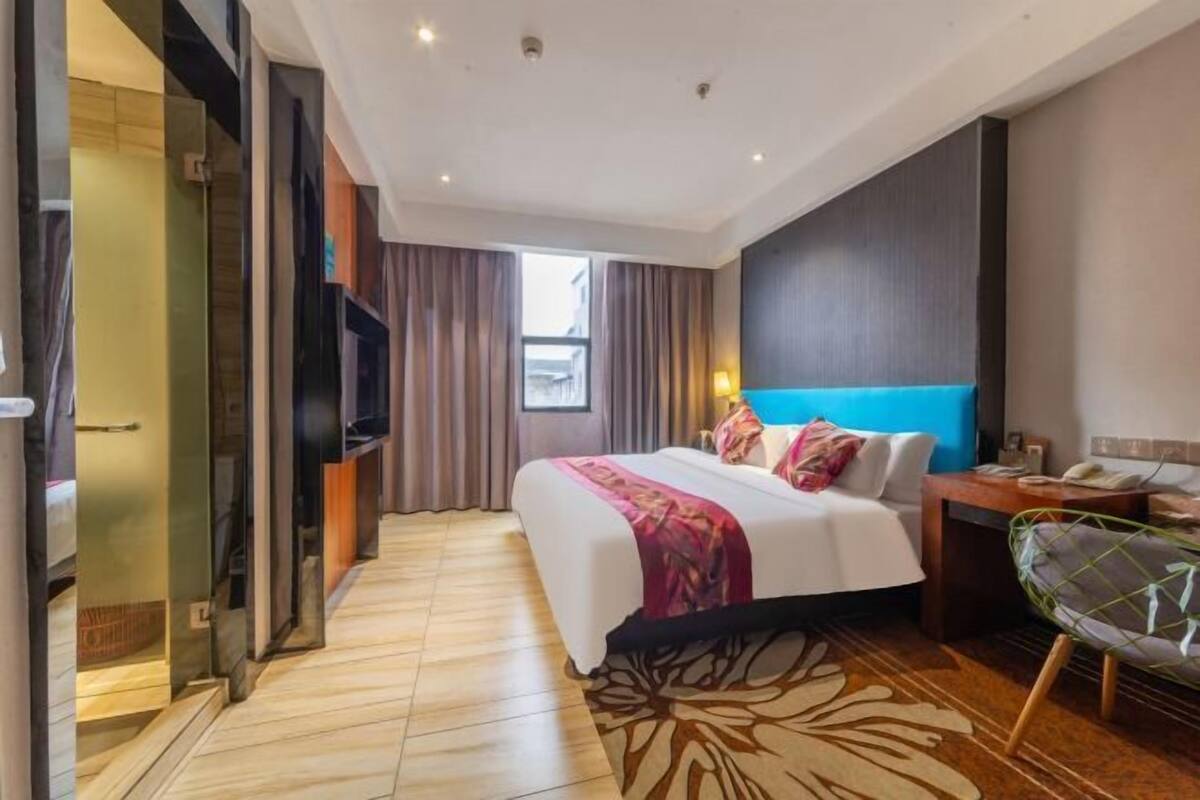 Une chambre d’hôtel moderne, dotée d’un grand lit, d’un bureau et d’une chaise.