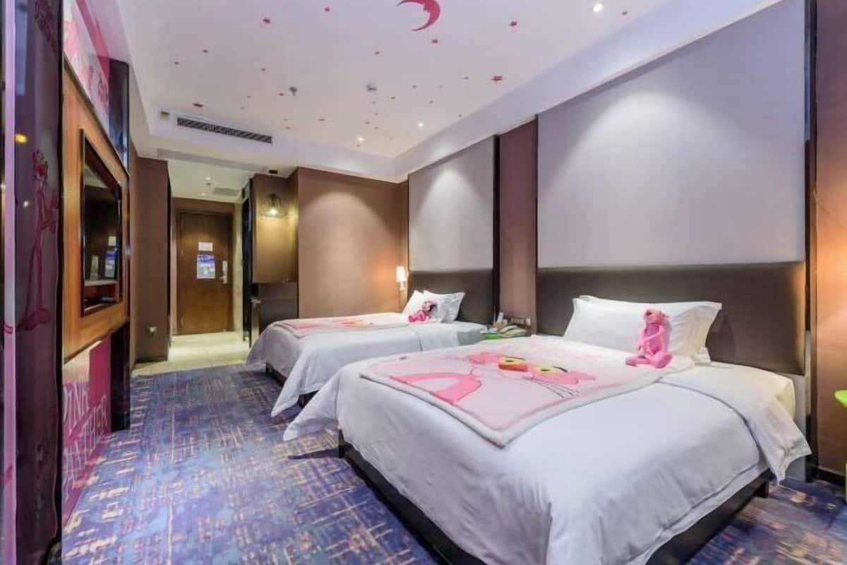 Une chambre d’hôtel avec deux lits, un grand miroir et un sol recouvert de moquette.