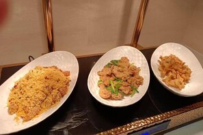 Trois assiettes blanches, chacune contenant un plat différent, sont posées sur une table.